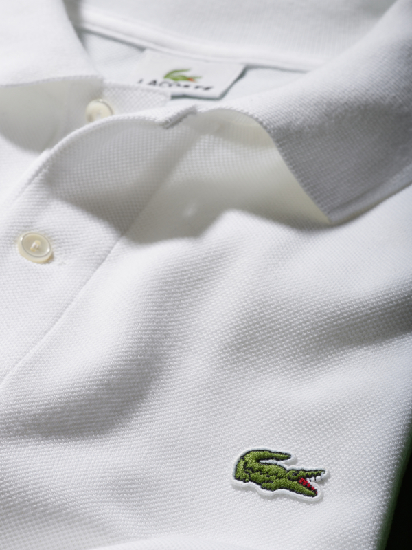 第一件LACOSTE Polo衫是白色的，比现在的款式略短，短袖，罗纹领。采用著名的“小凸纹网眼”（jersey petit piqué）面料，既轻薄又透气。1933年，René Lacoste与著名的针织面料制造商André Gillier合作，开始大规模生产缝有鳄鱼标志的翻领运动衫，他将这件Polo衫命名为L.12.12。