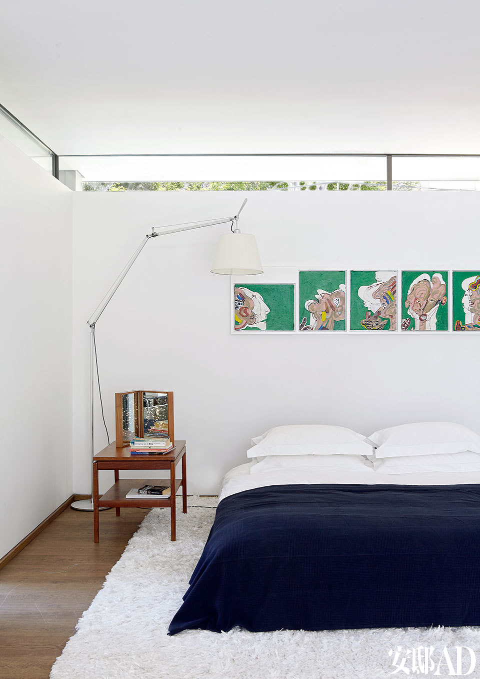 墙壁与天花之间留出的一小条玻璃面，不仅纳入美丽的自然光，让绿意也渗透进来。主卧室里的床来自B&B Italia，落地灯是Tolomeo Mega Terra来自Artemide，椅子则是复古的丹麦设计。