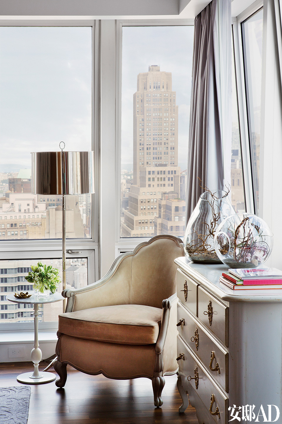 主卧室一角，窗外曼哈顿的街景仿佛触手可及。柜子为Coté France，美人椅来自Oly Studio，落地灯来自Robert Abby。