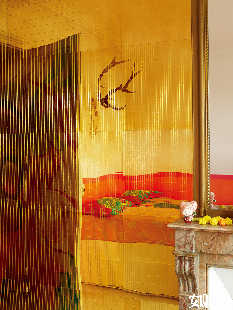 屏风上有印度的神话和宗教人物。金色镜面墙上映射出颜色香艳的床，镜面墙来自巴黎的King Mirror。