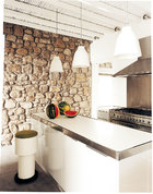 纯白的现代厨房里， 只一牙绿皮红瓤的 西瓜，也像艺术品一般装点出一个午后的甜梦。厨房里，厨具来自Carma Cucine，电器来自Smeg，圆形的凳子是一件古着物品，岛台上方的吊灯Caravaggio是Cecilie Manz为Lightyears设计的。