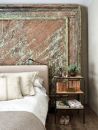 古旧的纹路、 古色的光泽、亚麻或丝绒布料的质感，成就了这个家温馨雅致的基调。主卧室，用作床头板的是古董印度木板，床头桌由Toni设计，床上铺着纯麻床单。
