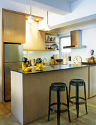 设计师Stefano拆除了原本的隔断墙，由此增加了厨房的空间，使它更为敞亮，并与起居室相连通。橡木橱柜搭配合适的早餐吧台，确保了空间的最大化利用。