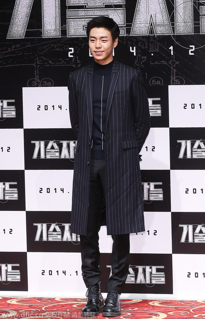 韩国首尔当地时间2014年11月18日，李玹雨出席电影《技术者们》制作发表会。中高领竖纹套头衫与及膝竖纹大衣外套合二为一，八孔军靴更是让整体平添时装式硬派。