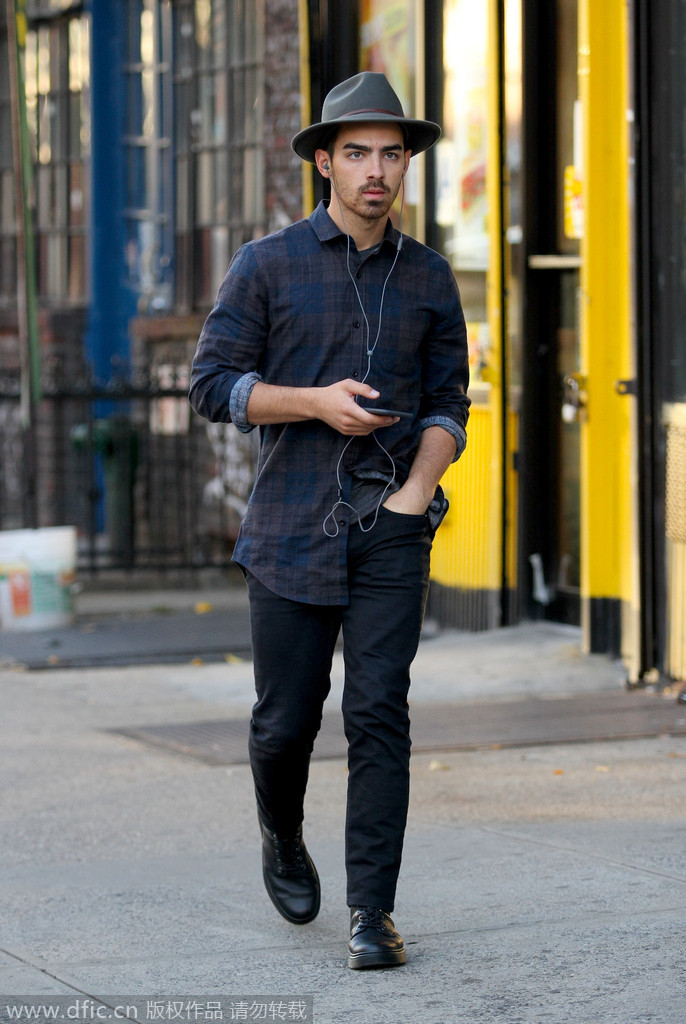 Joe Jonas行走曼哈顿街头，一样的夸张长衬衫，一样的音乐制作人范儿，一样需要一顶宽檐帽来锁定这个stytle,腿短了没事，艺术气息可长了。