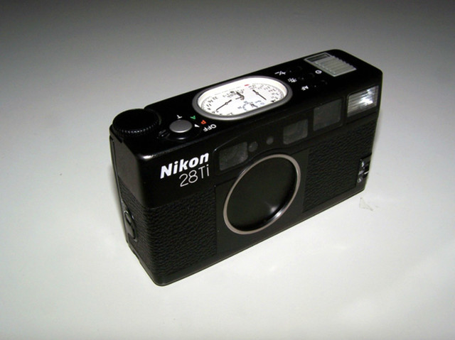 NO.2 Nikon 28Ti
尼康这台28Ti和35Ti都带一个Ti，一方面代表了机身采用了“钛”材料，另一方面说明价格不会低。该相机采用的是28mm F2.8镜头。相机的外观设计和28Ti类似，十分具有触感。采用“钛”金属的最大优点就是，按快门的声音十分清脆好听，几乎没有机震的感觉。该相机机身上也有椭圆形指针显示屏，显示各参数信息。
