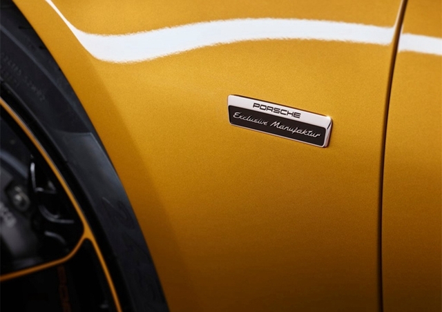 911 Turbo S Exclusive Series的乘客舱优雅而独特。18向可调节运动座椅覆有两层穿孔皮革。内层的金黄色双条纹带来令人惊叹的视觉效果。此外，头枕上的接缝与“Turbo S”字样也采用了金黄对比色。车顶内衬采用带金黄色双条纹的Alcantara面料，而碳纤维内饰组件的装饰条上还配有上等铜线。
