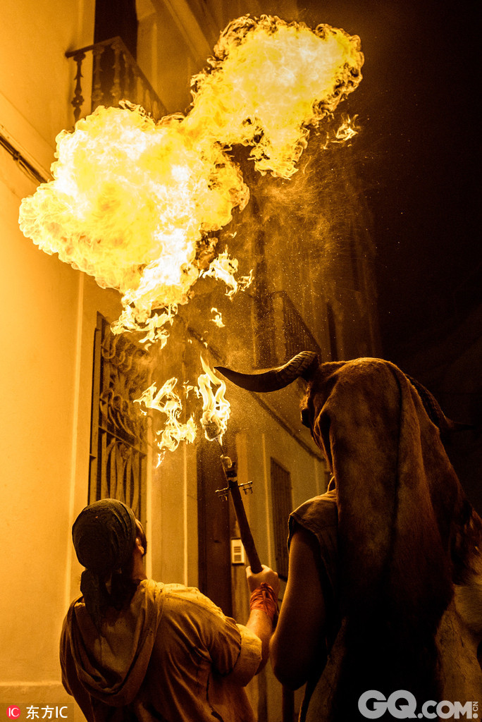 西班牙加泰罗尼亚锡切斯，当地举行夜火狂欢，人们进行喷火表演。