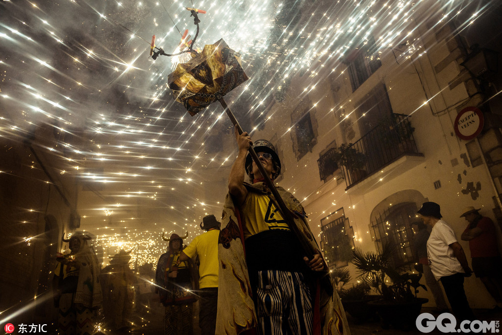西班牙加泰罗尼亚锡切斯，当地举行夜火狂欢，人们进行喷火表演。