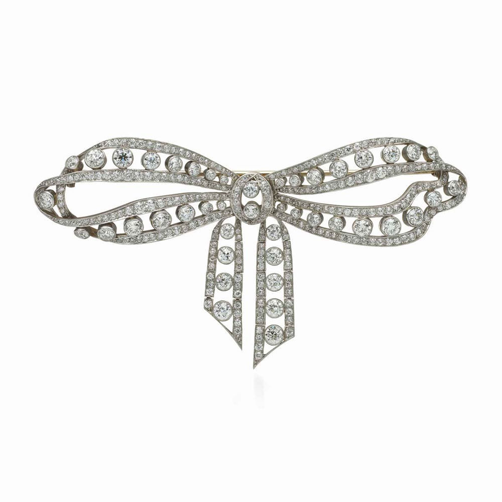 此款镶嵌303颗古典欧式切割钻石的蝴蝶结胸针，是一款从花环风格过渡到装饰艺术风格的典型代表作品。在四周密镶一圈圈独立钻石的蝴蝶结胸针盛行于1910-1920年间
