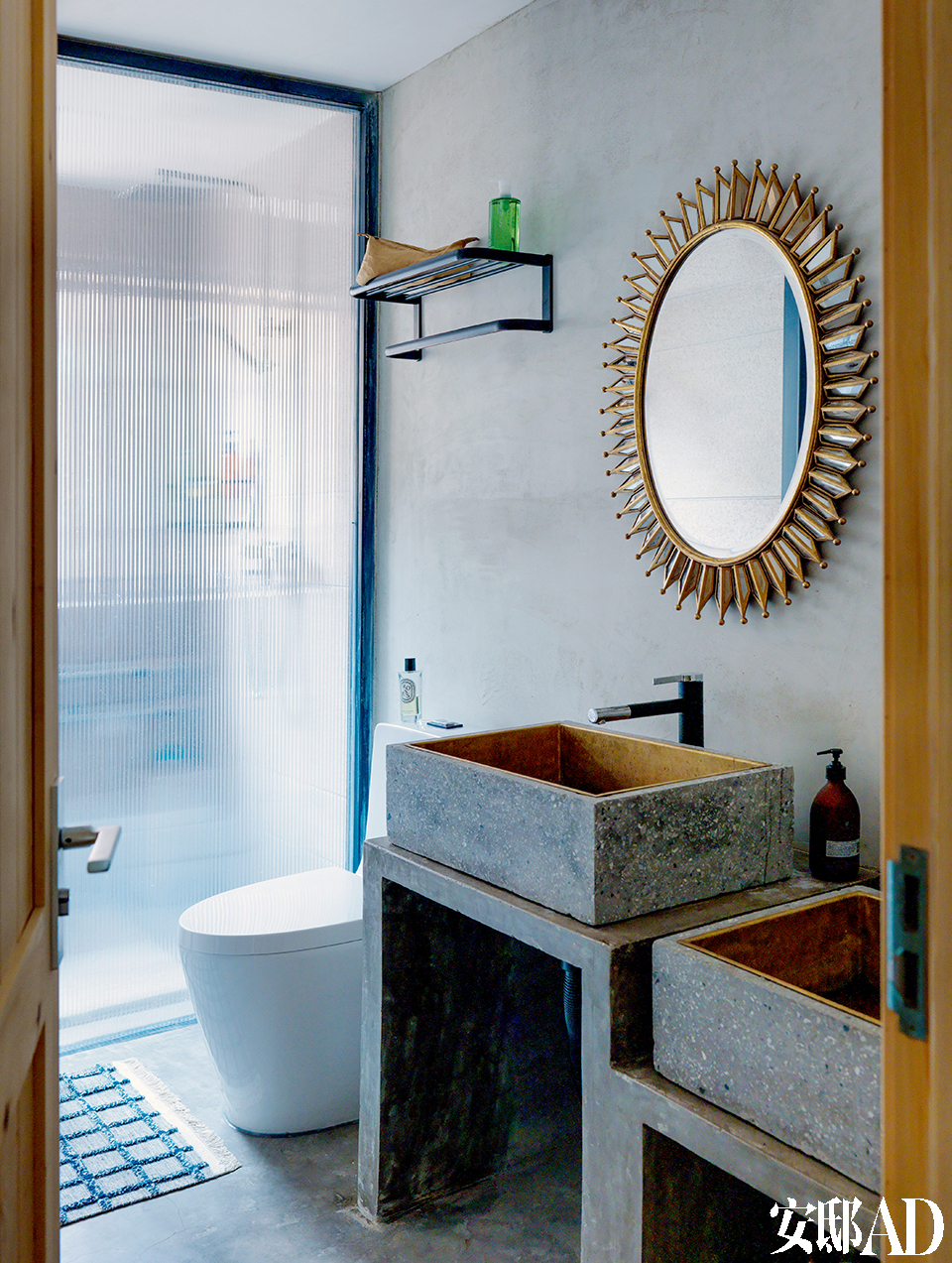 卫生间被主人Cola打造成简约风格，洗手池是来自A+A Workshop特制的水磨石嵌黄铜洗手台。远处的香氛瓶来自法国品牌Diptyque。