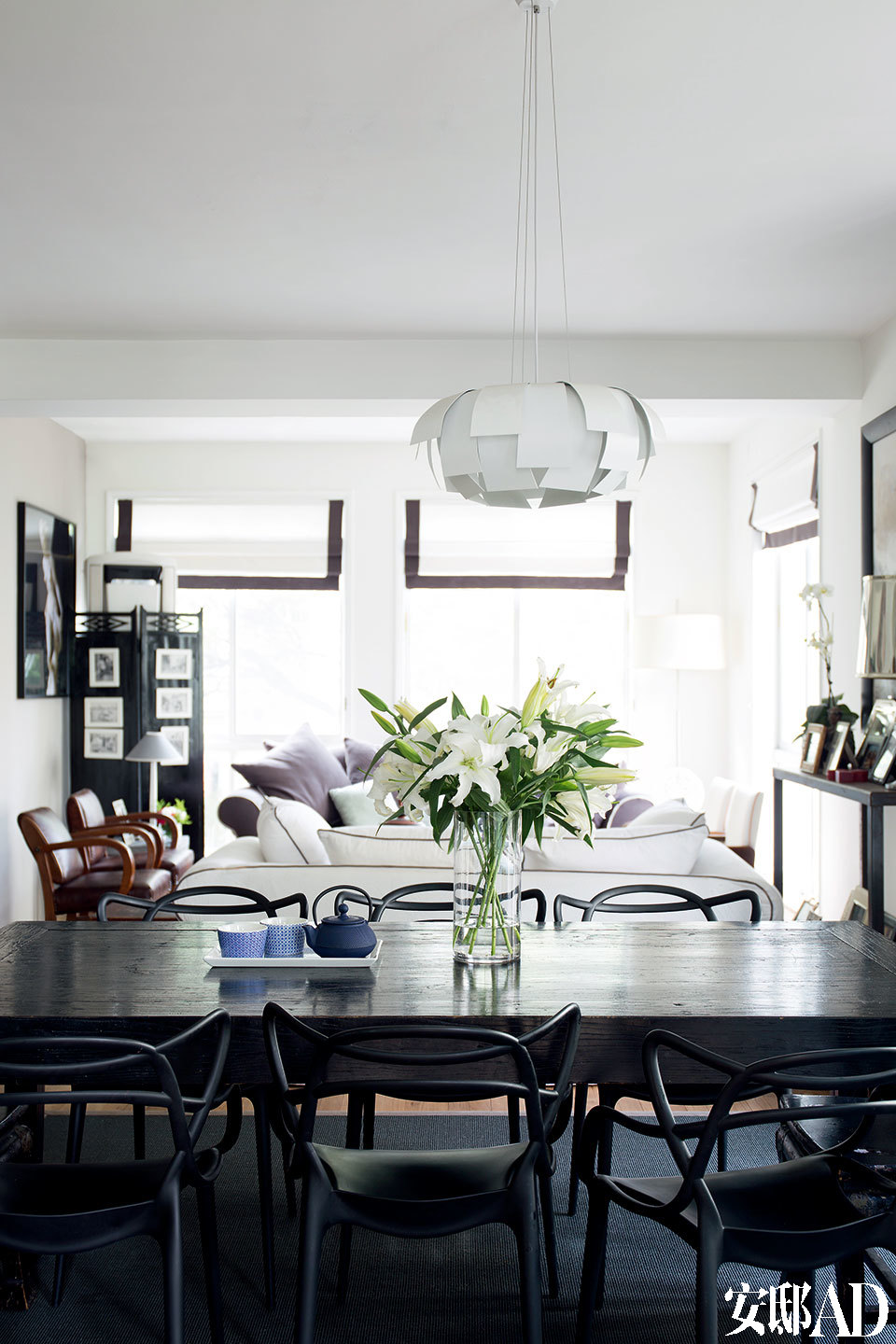 一层起居室内的色彩以白色为主，无论是沙发还是靠垫都以细细的黑边“勾勒”，包括餐椅的选择也是黑色线条的“构成”。这些选择与搭配构成了室内风格的统一。