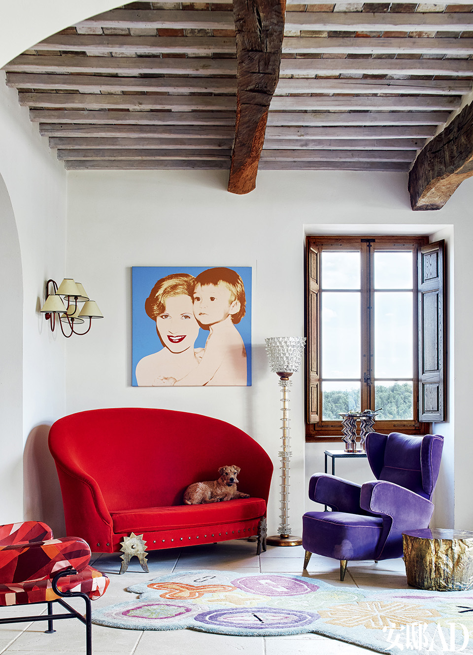  红色沙发来自法国设计师拍档Garouste &Bonetti，紫色扶手椅来自Gio Ponti，玻璃坐灯来自Barovier&Toso。窗边控制台上摆放的玻璃花瓶来自Ettore Sottsass（1917-2007）。左侧墙灯来自法国设计师Jean Royère（1902-1981）。画作来
自安迪·沃霍尔，画上是Suzanne和儿子Marc。