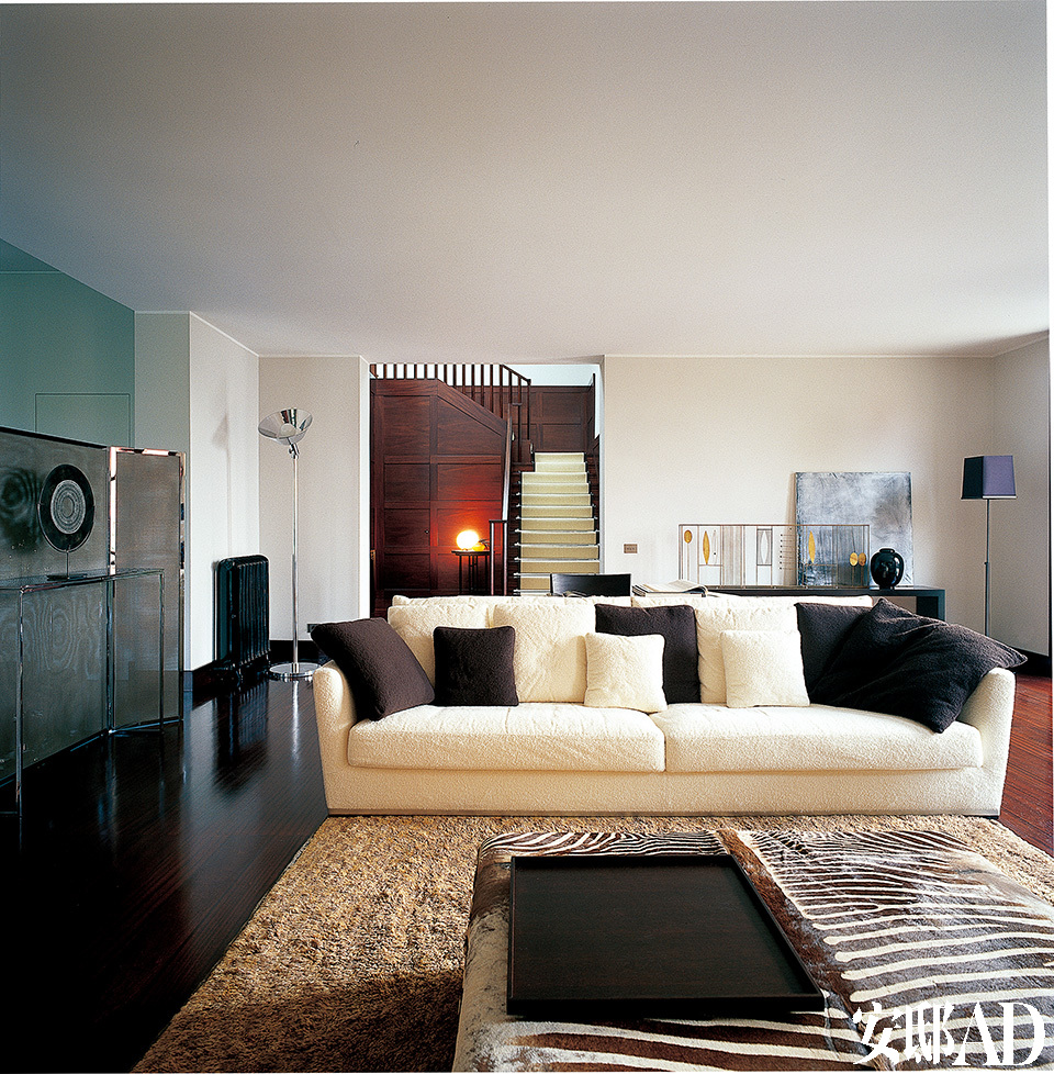 客厅中的大沙发为Maxalto品牌，分隔餐厅与客厅的小屏风出自意大利设计大师Antonio Citterio之手，镀黄铜框架内搭配了一种灰色金属细网。