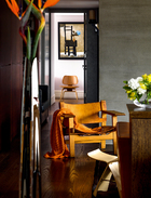 从客厅经走廊可以看到女儿房
间的墙壁，王伟忠专门为女儿挑选了董小蕙的“黑椅子“油画作品，因为他觉得它既优雅又有家的感觉。来自Børge Mogensen设计的“西班牙椅”（丹麦仓库提供），其椅子上的橘色毛毯来自品牌Design House Stockholm（北欧橱窗提供）。