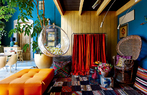 Raf 特别喜欢能带给人无限生机的亮色，比如蓝色、起居室里明亮的橙色，呼应着满室植物，真是明快开心。右侧的是Emanuelle座椅，花地毯购自北非的马拉喀什。橙红色的电视帘由摩洛哥毛毯制成，左侧悬挂的泡泡椅来自Eero Aarnio。