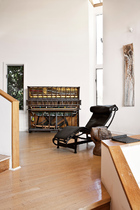 谭盾的钢琴装置作品靠着墙，旁边是柯布西耶的LC4椅子和18世纪的中式木墩。