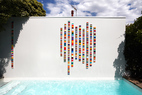 醒目的泳池背景墙上，墨尔本著名艺术家John Nicholson 创作了有机玻璃材质的壁挂式雕塑，绚丽的彩色条纹让之前院中的空阔和黯淡感一扫而空。