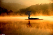 安徽皖南黟县，拍摄的晨曦奇墅湖美景。当日，在安徽皖南黟县奇墅湖的平静湖面上，被一层蒸腾流动的雾气所...