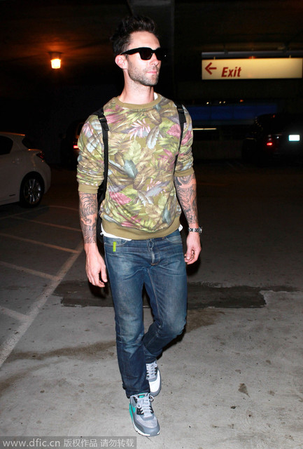 2014年10月25日星期五，Adam Levine现身巴黎返回LA的机场。热带印花圆领套头衫与双肩背和黑超街头风十足，一双马卡龙绿配色的运动鞋为清新的整体锦上添花，当然，重点是那副永远都不会藏起来的花臂。
